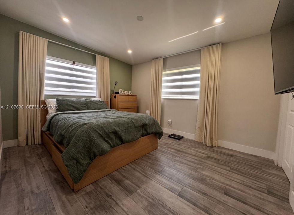 Wood-finish flooring, recessed lighting, and dual-toned wall finishes