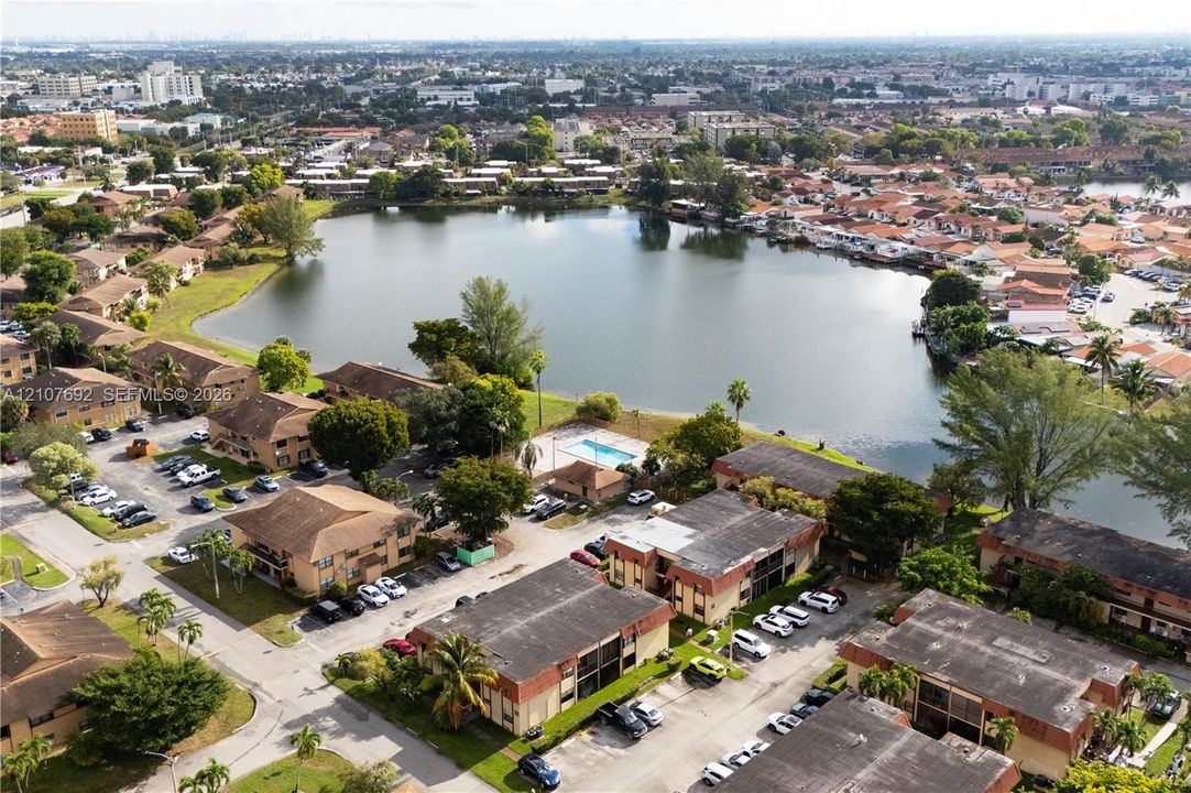Aerial perspective of the community featuring a central lake and a shared swimming pool