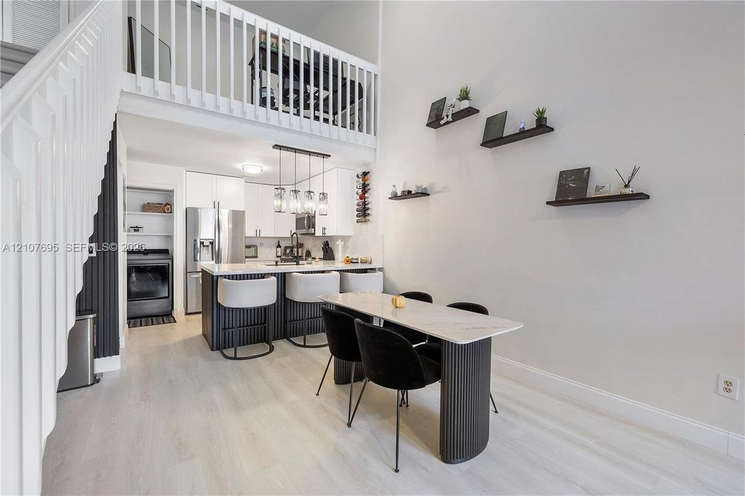 Double-height living area featuring a wood-finish staircase