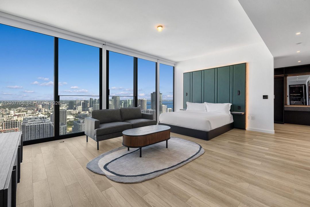 Floor-to-ceiling windows, wood-finish flooring, built-in paneling with integrated recessed lighting, and recessed ceiling lights