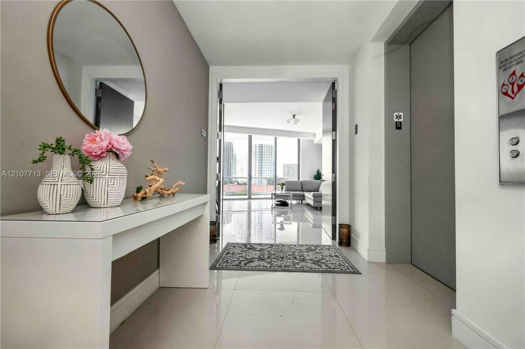 Entryway featuring polished tile flooring, direct elevator access, and floor-to-ceiling windows