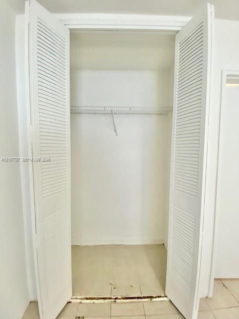 Reach-in closet featuring white louvered bifold doors and wire shelving