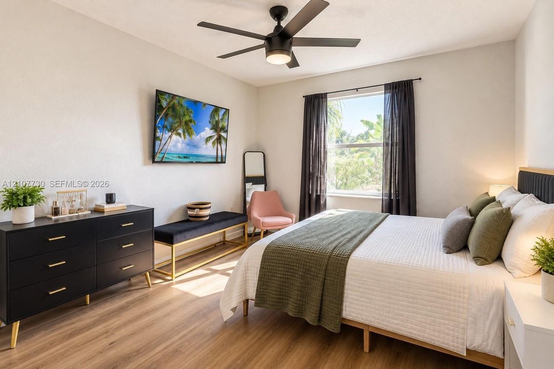 Room featuring wood-finish flooring, a matte black multi-blade ceiling fan with integrated lighting, and a single-pane window