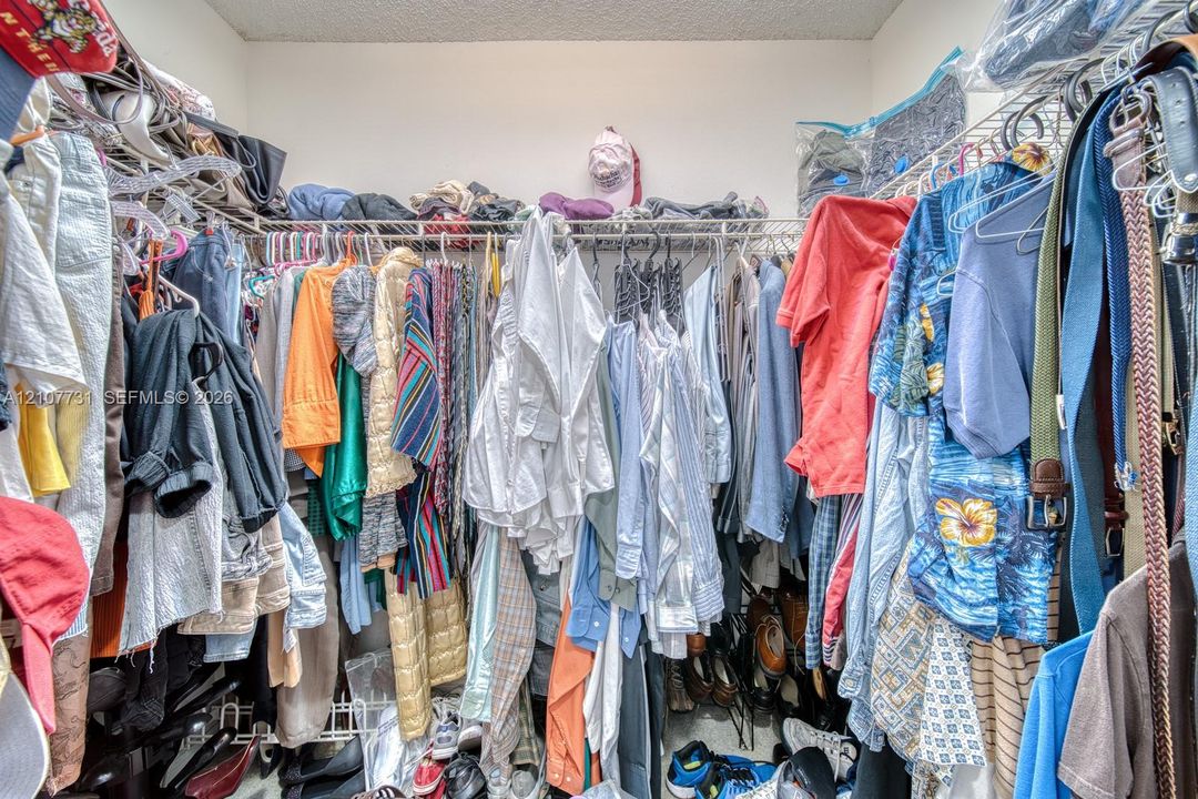 Walk-in closet featuring multi-tiered wire shelving and integrated hanging rods