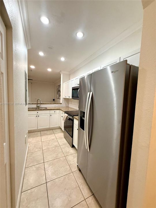 Kitchen featuring white cabinetry, stone-finish countertops, stainless steel side-by-side refrigerator, recessed lighting, and tile flooring
