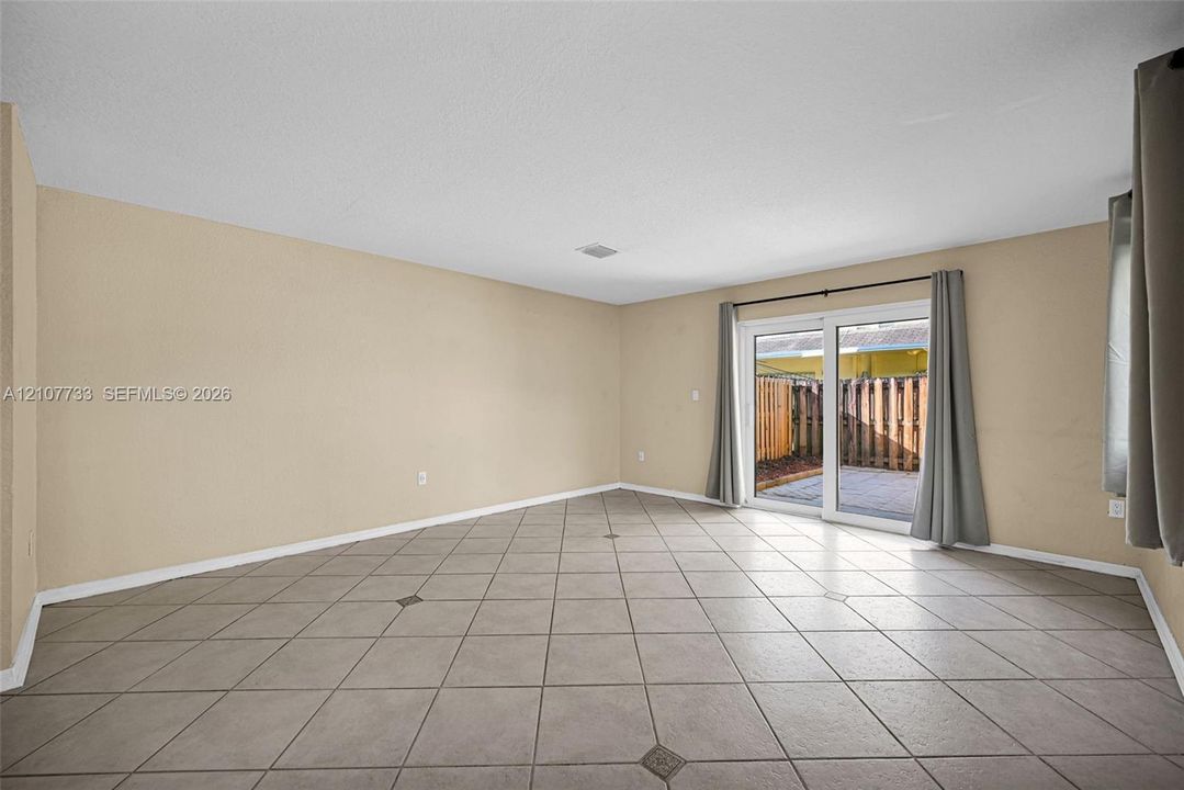Interior space featuring diagonal ceramic tile flooring and sliding glass doors leading to a paved outdoor area
