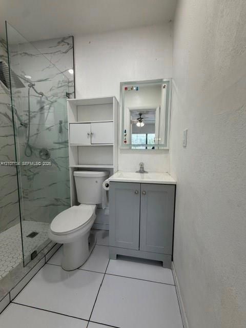 Walk-in shower with floor-to-ceiling stone-finish tile surround and hexagonal floor tile, vanity with integrated countertop, and LED-bordered wall mirror