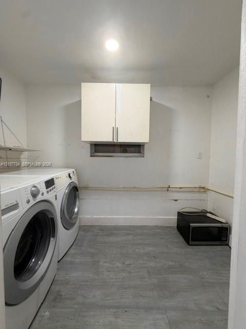 Dedicated laundry room featuring a front-load washer and dryer, abundant cabinetry with stainless steel hardware, concrete flooring, and recessed ceiling lighting for optimal functionality