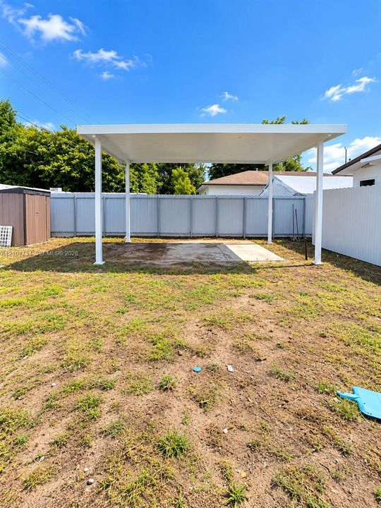 Backyard featuring a covered patio, concrete slab, and privacy fencing