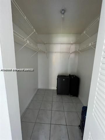 Walk-in closet featuring white wire shelving and ceramic tile flooring