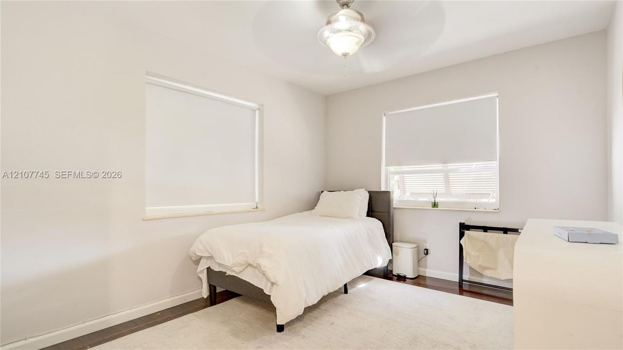 Neutral wall finishes, wood-finish flooring, recessed windows, and a central ceiling-mounted light fixture
