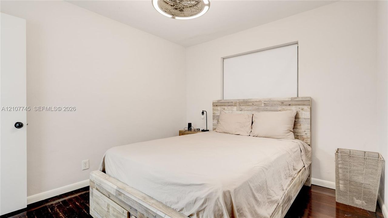 Room featuring wood-finish flooring, a flush-mount circular ceiling light fixture, and a single window