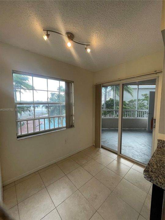 Ceramic tile flooring, multi-pane window, sliding glass door, and a three-light track fixture