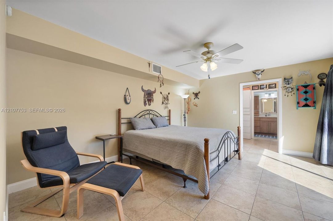 Neutral-toned room featuring large-format tile flooring, recessed ceiling lighting, and a central ceiling fan