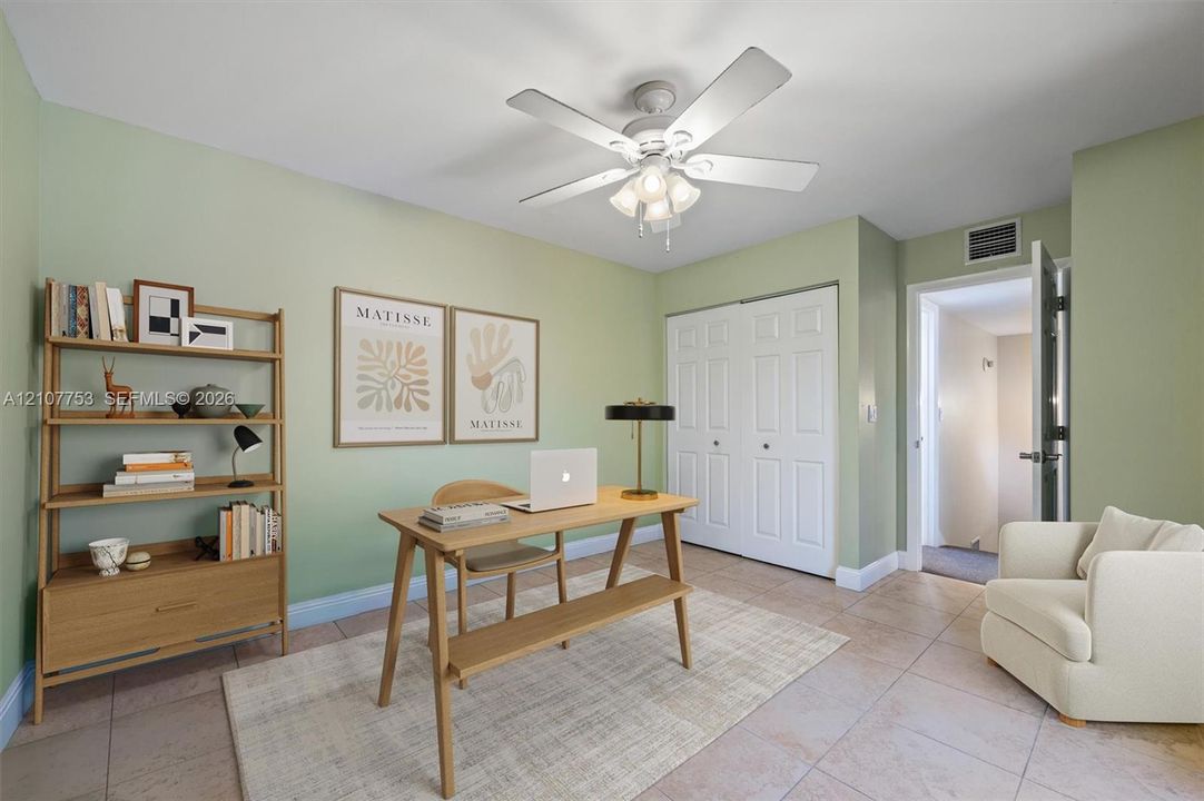 Room featuring tile flooring, a central ceiling fan with integrated lighting, and a double-door closet