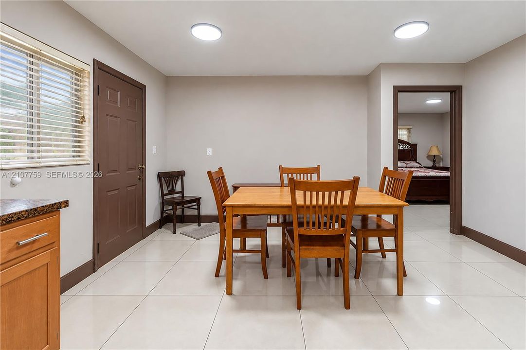 Large-format porcelain tile flooring, recessed ceiling lighting, and solid-panel door with architectural trim