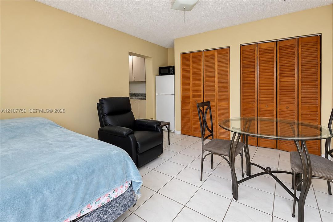 Ceramic tile flooring, built-in wooden bi-fold closet doors, and a ceiling-mounted light fixture