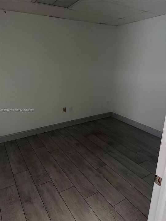 Room featuring wood-finish flooring and a drop ceiling