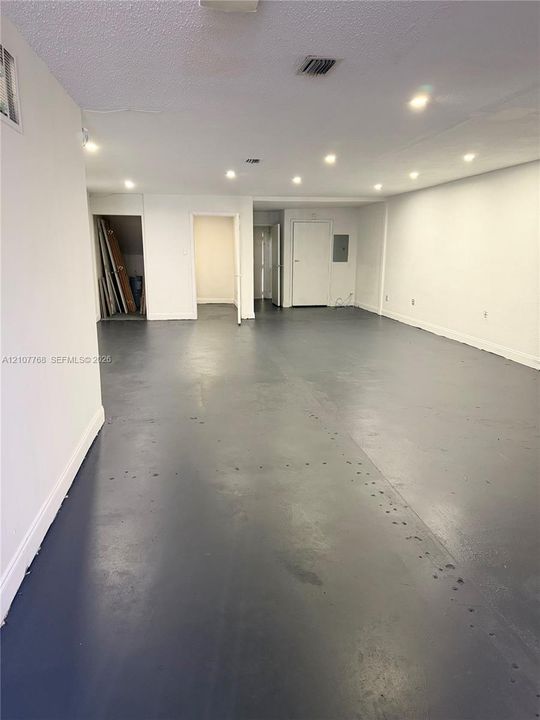Open interior featuring painted concrete flooring, recessed lighting, and white walls