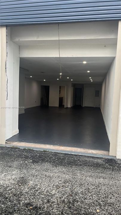 Expansive interior space featuring a roll-up security door, high-durability epoxy flooring, and integrated recessed lighting