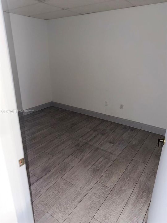 Interior room featuring wood-finish flooring and neutral wall paint