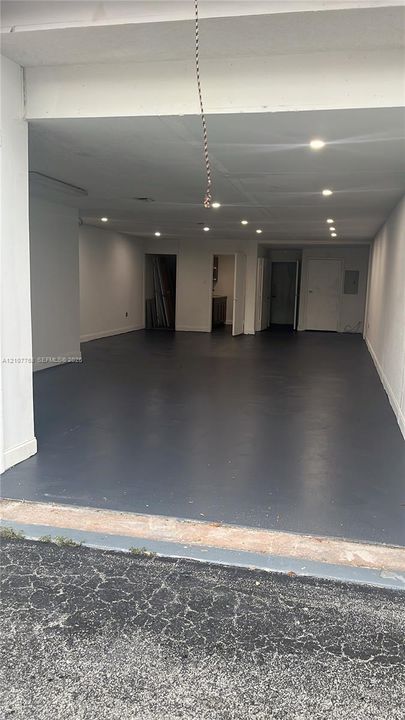 Expansive garage space featuring seamless epoxy flooring, recessed ceiling lighting, and multiple interior doorway entries