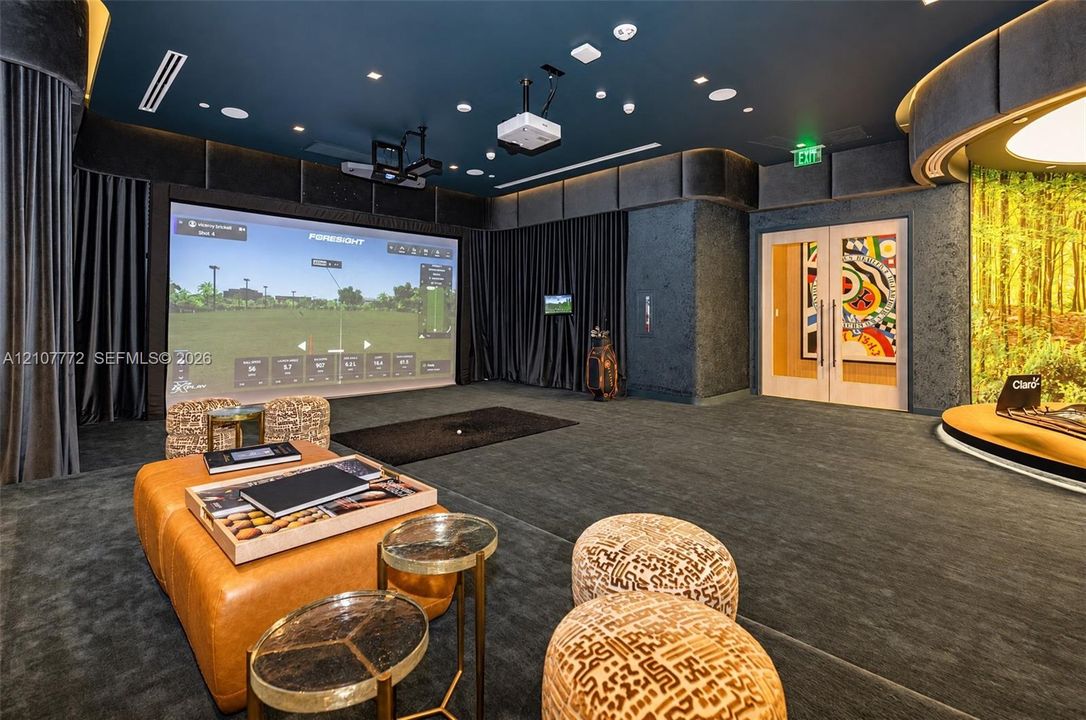 Dedicated recreation room featuring a built-in golf simulator, integrated projection system, recessed cove lighting, and floor-to-ceiling drapery