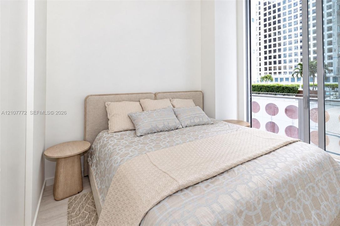 Floor-to-ceiling sliding glass door, neutral interior walls, and light-toned wood-finish flooring