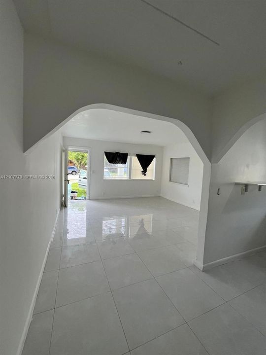 Interior space featuring large-format polished tile flooring and distinct architectural arched transitions
