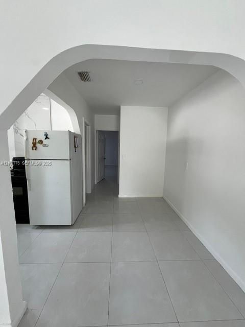 Arched architectural detail featuring large-format neutral tile flooring and a clean-lined interior aesthetic