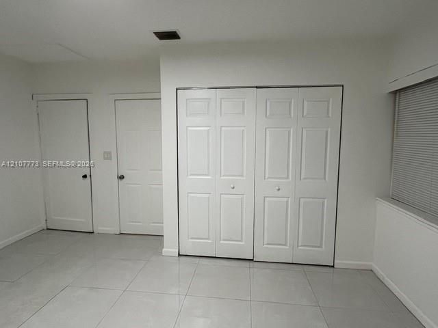 Large-format tile flooring, dual bi-fold closet doors, and solid-core interior doors