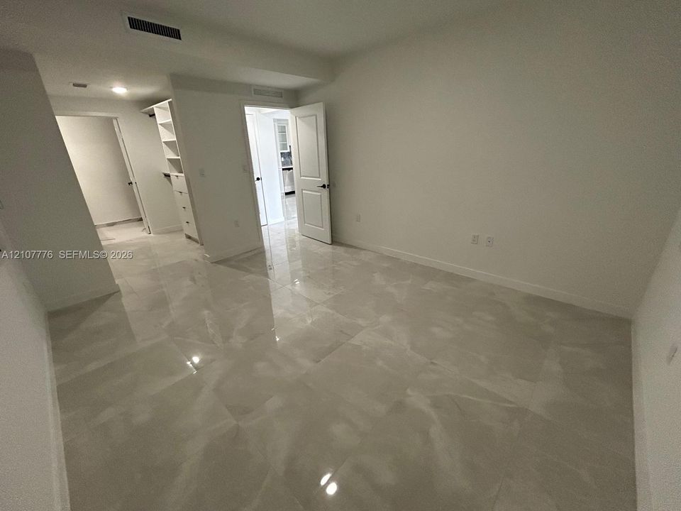 Interior room featuring large-format tile flooring, built-in shelving, and recessed ceiling lighting