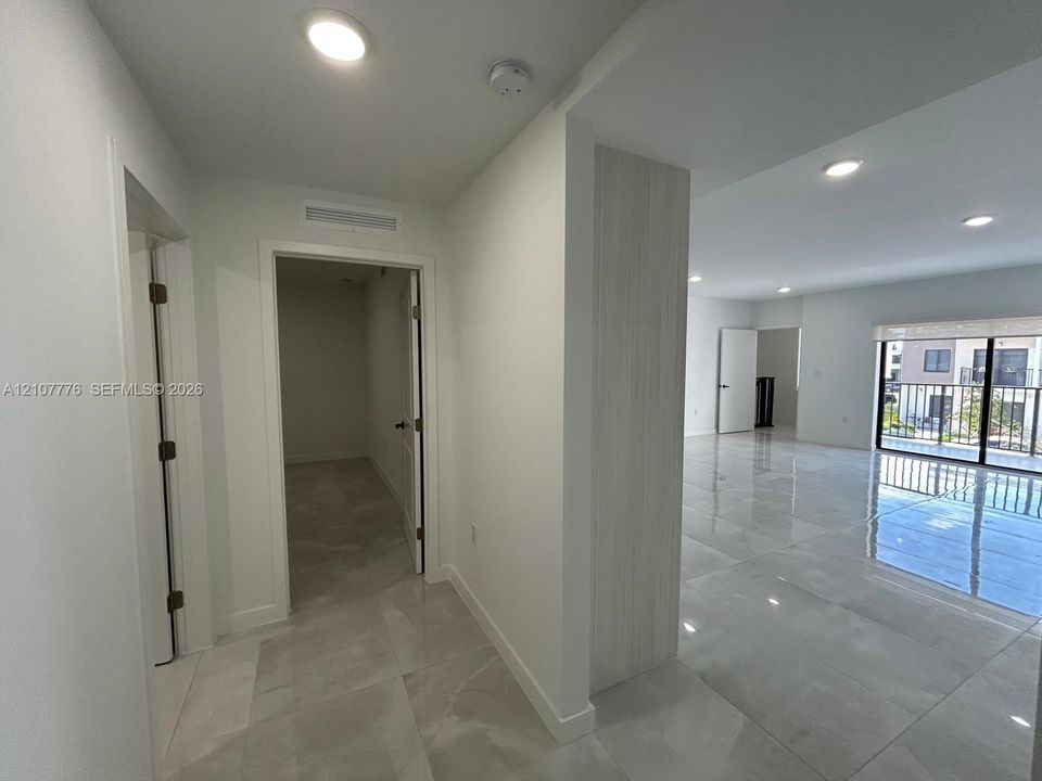 Large-format polished tile flooring, recessed ceiling lighting, and a neutral color palette