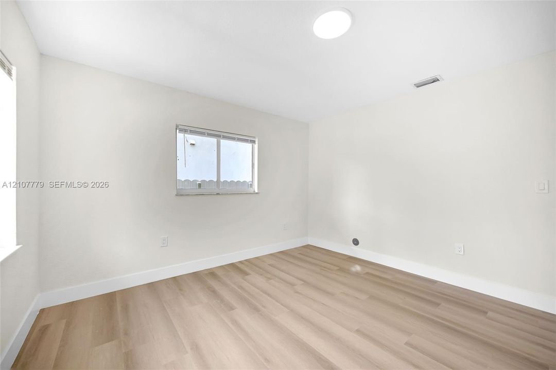 Neutral interior room featuring wood-finish flooring, a recessed ceiling light, and horizontal sliding windows