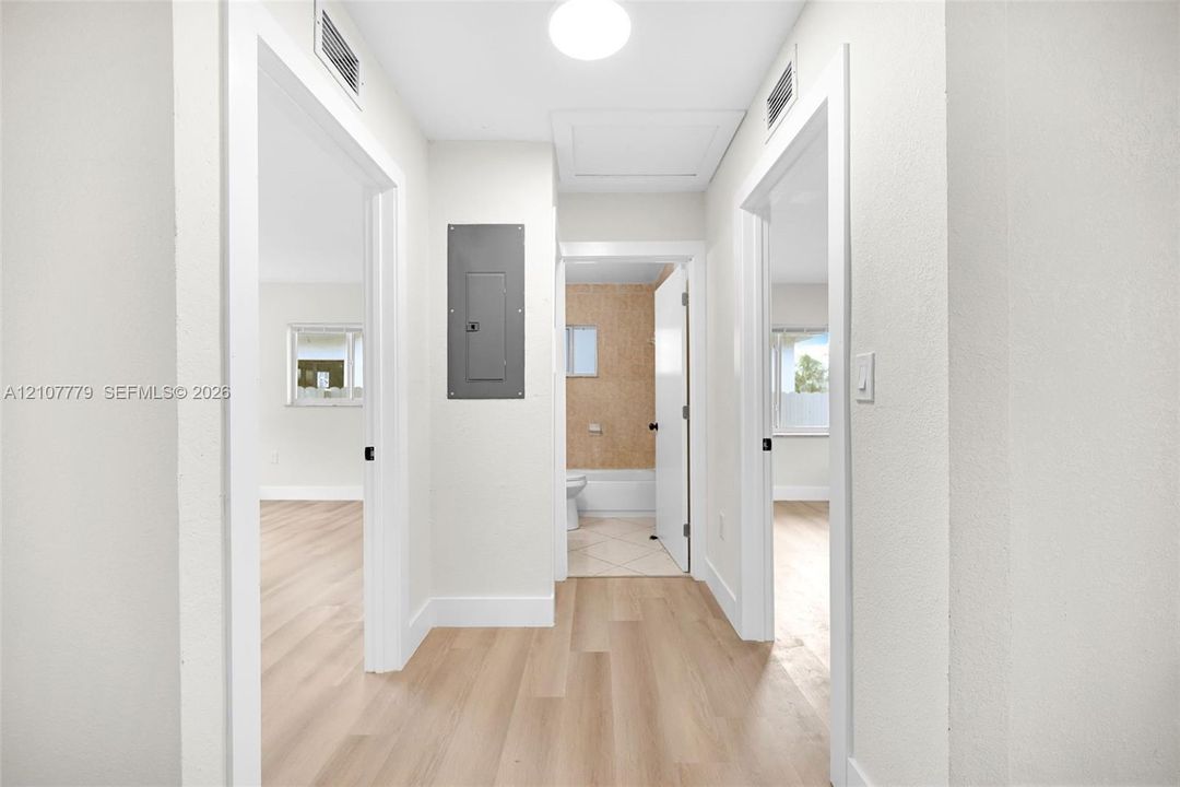 Hallway featuring light wood-finish flooring, neutral wall tones, and recessed ceiling lighting