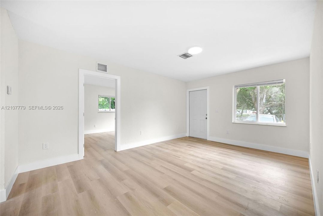 Neutral interior featuring wood-finish flooring, recessed ceiling lighting, and a single-pane window