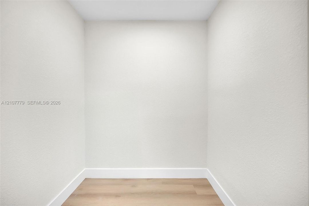 Neutral-toned interior alcove featuring smooth wall surfaces and light wood-finish flooring