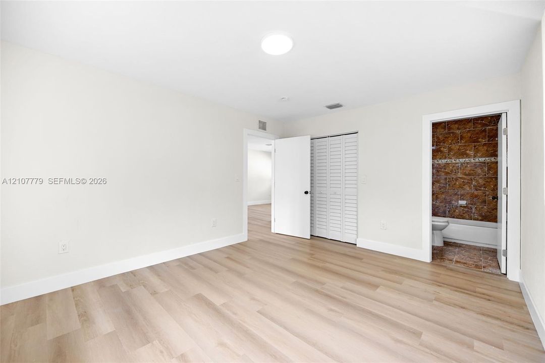 Interior room featuring wood-finish flooring, recessed ceiling lighting, and a bi-fold closet