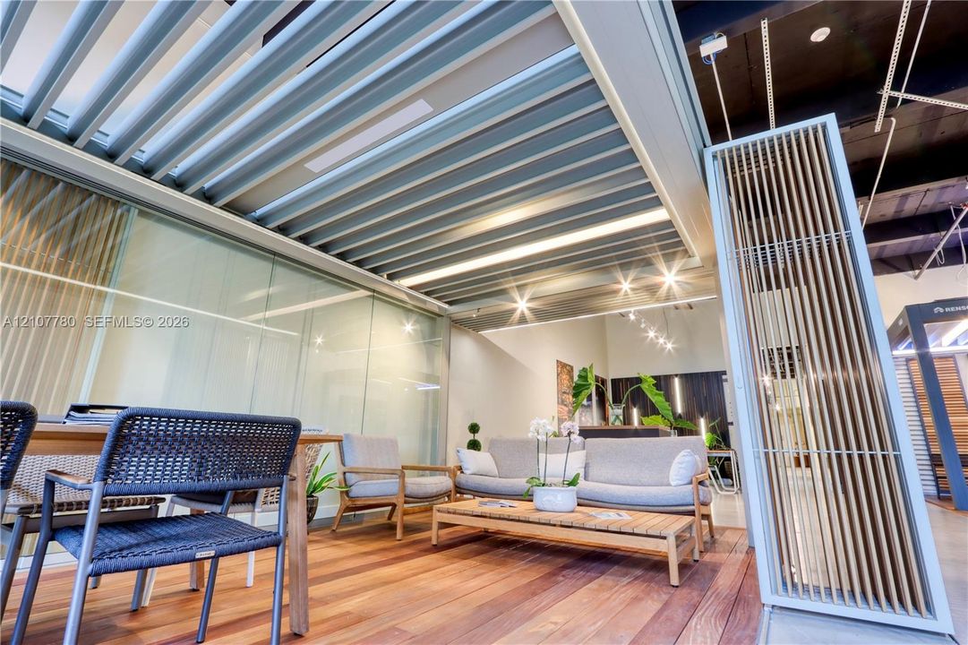 Customized outdoor living area featuring a louvered pergola roof system, wood-finish decking, integrated recessed lighting, and vertical slatted privacy screen