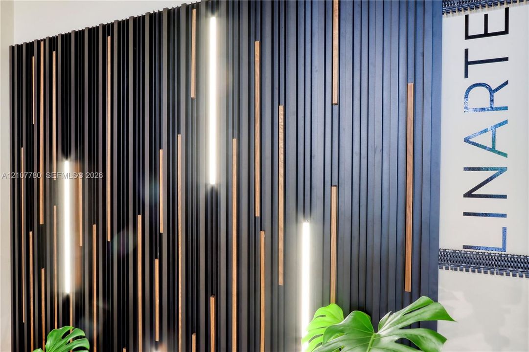 Textured accent wall featuring vertical dark-finished slats, integrated linear lighting, and wood-tone accent strips