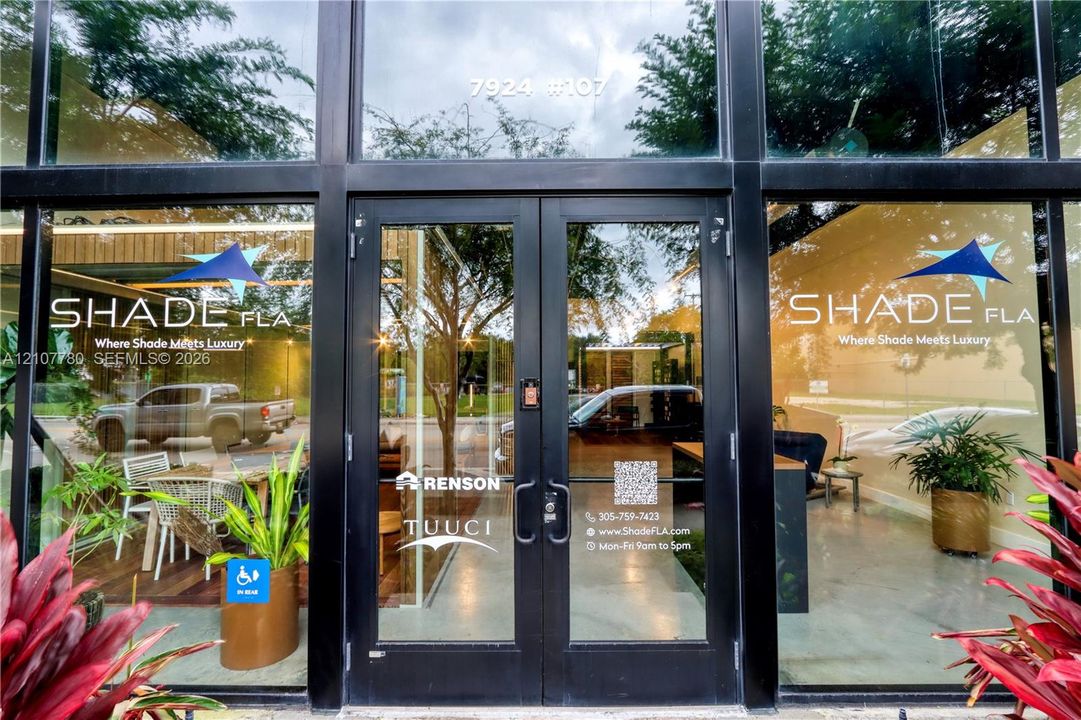 Floor-to-ceiling glass storefront featuring a black metal frame and double-door entry