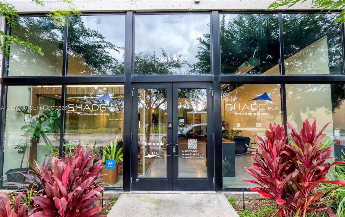 Floor-to-ceiling storefront glass facade with black metal framing and double-door glass entry