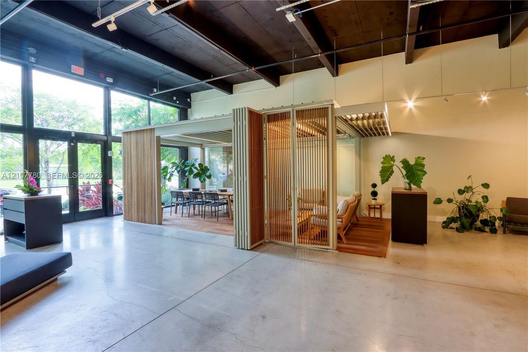 Polished concrete flooring, exposed wood-beam ceiling, floor-to-ceiling glass paneling, and custom slatted wood screening