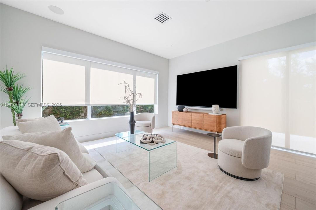 Living space featuring expansive windows, wood-finish flooring, recessed lighting, and automated roller shades