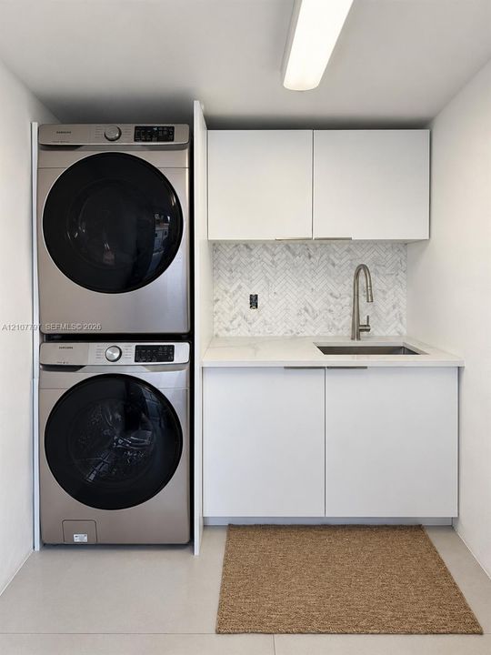 Laundry Space featuring stacked washer/ dryer