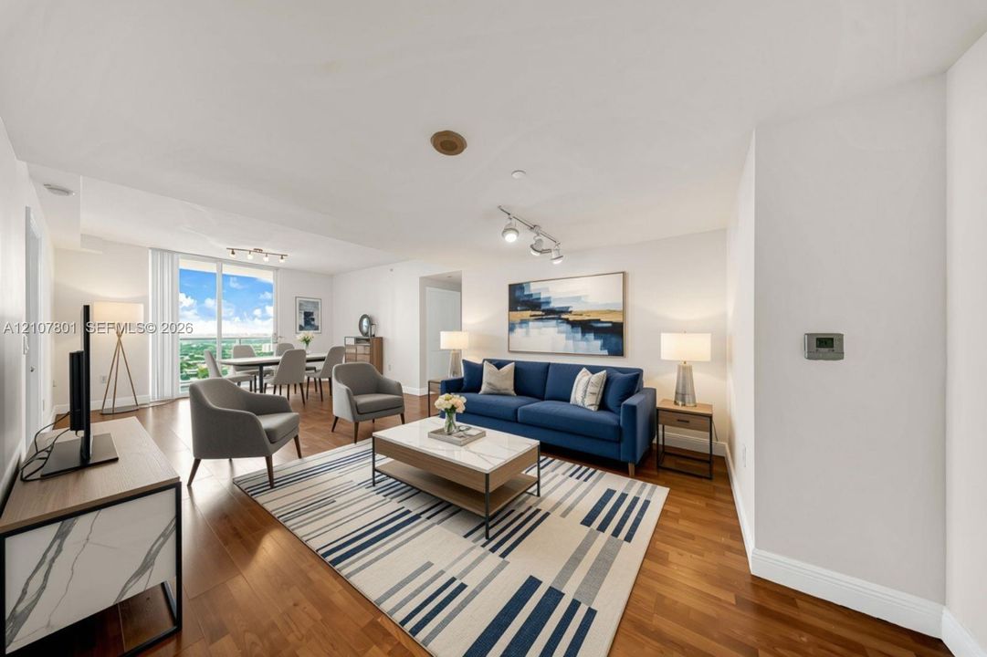 VIRTUALLY STAGED - Open-concept main living area featuring wood-finish flooring, floor-to-ceiling windows, and track lighting