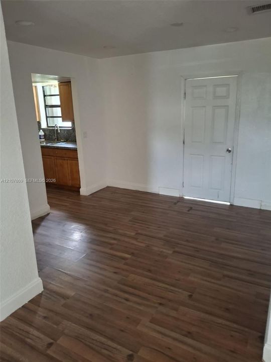 Interior space featuring wood-finish flooring, recessed ceiling lighting, and a six-panel door