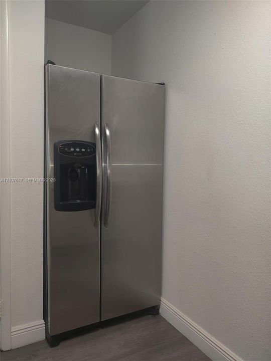 Stainless steel side-by-side refrigerator featuring an integrated water and ice dispenser