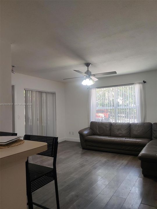 Interior space featuring wood-finish flooring, a ceiling fan with integrated lighting, and sliding glass doors