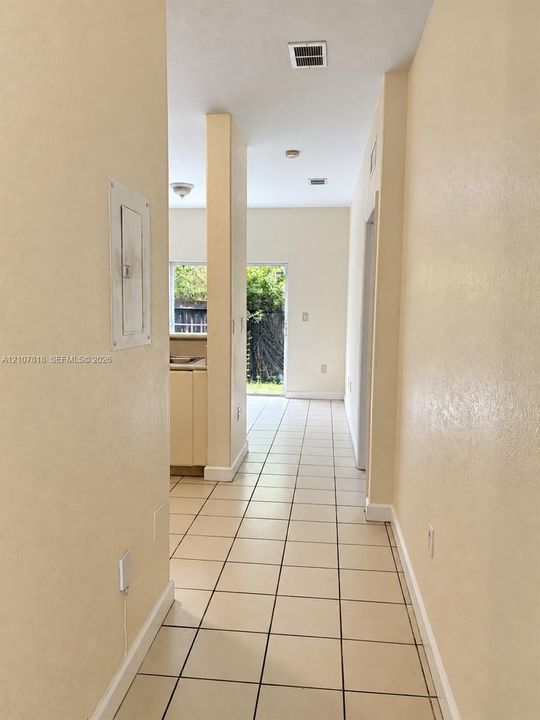 Ceramic tile flooring, neutral wall finishes, and a glass sliding door providing exterior access